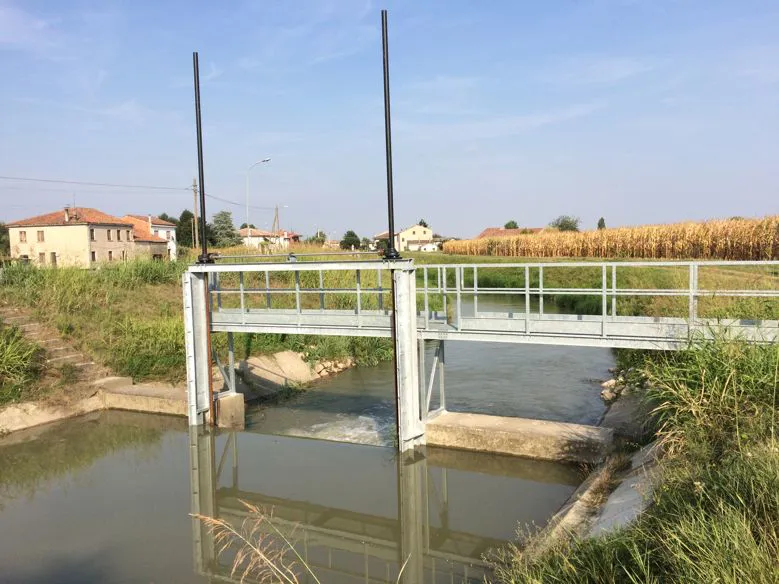 Paratoia idraulica in acciaio installata su canale di bonifica per la regolazione del flusso d’acqua
